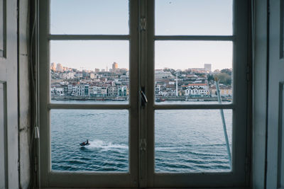 Cityscape by sea seen through window