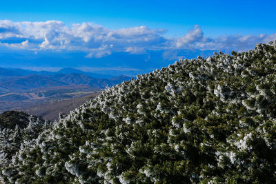 Scenic view of mountains against blue sky