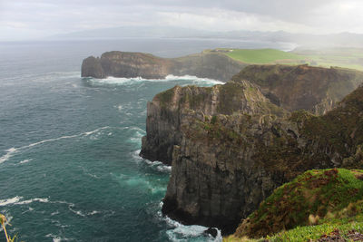 Rock formations by sea against sky