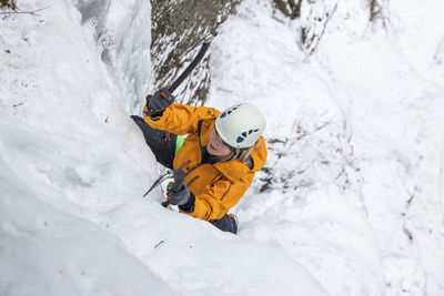 High angle view of woman ice climbing at white mountains during winter