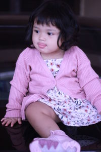 Girl looking away while sitting on sofa