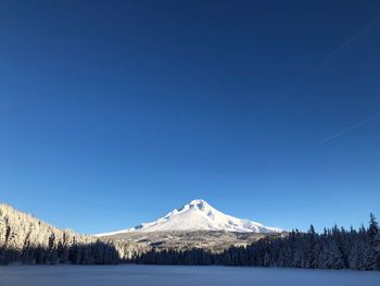 Scenic view of snowcapped mountains against clear blue sky