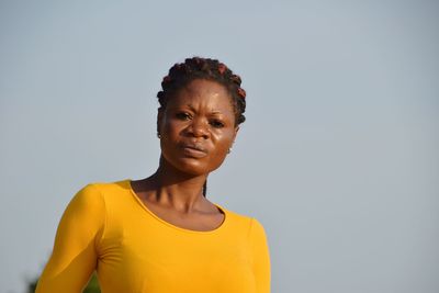 Portrait of smiling young woman against gray background