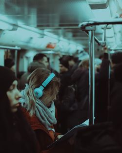 Woman looking at camera while sitting in bus