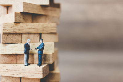 Close-up of figurines on wooden toy blocks