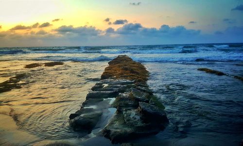 Scenic view of beach against sky during sunset