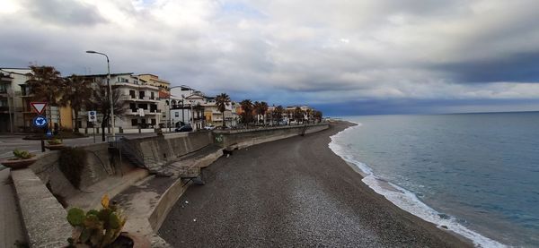 Panoramic view of beach and buildings against sky