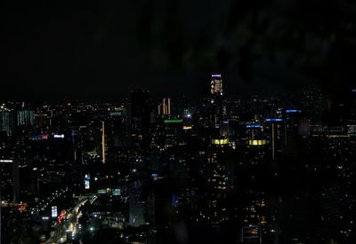 Illuminated cityscape against sky at night