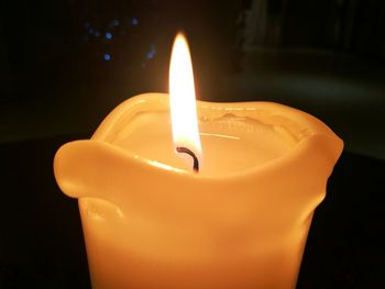 Close-up of burning candle in darkroom