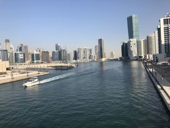 Scenic view of sea and buildings against clear sky