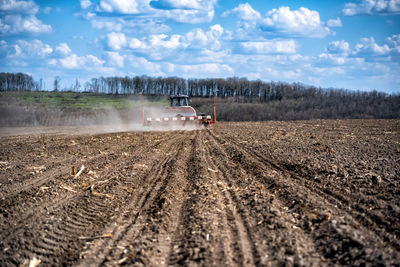 Panoramic view of vehicles on road amidst field against sky