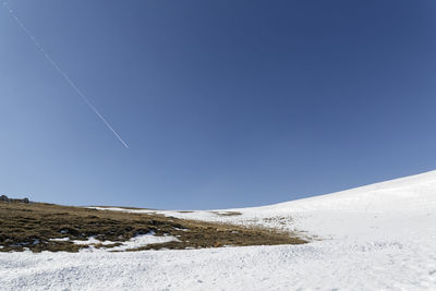 Scenic view of snowcapped mountains against clear blue sky