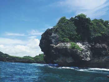 Scenic view of cliff and sea against sky