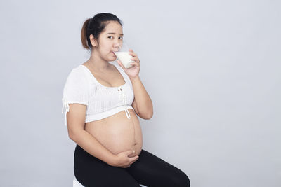 Young woman standing against white background