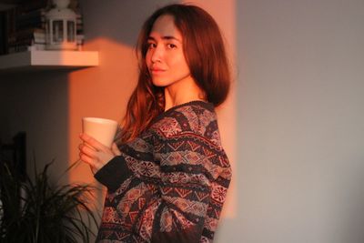 Portrait of young woman drinking coffee