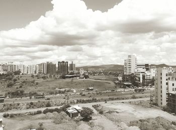 Buildings in city against cloudy sky