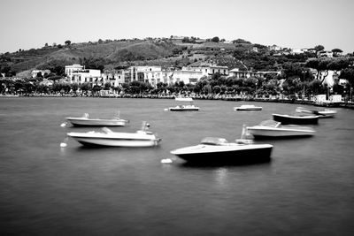 Boats moored in harbor against clear sky