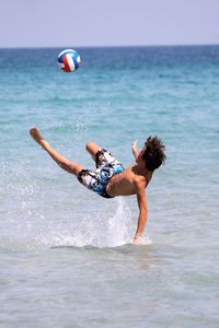 Man playing in sea football passion 