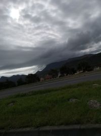 Scenic view of field against cloudy sky