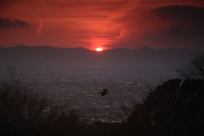 Silhouette of mountain against cloudy sky at sunset