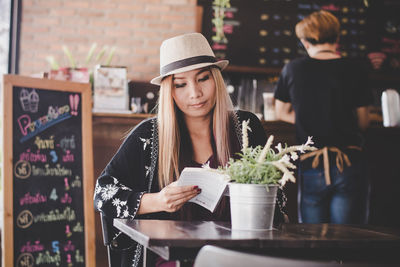 Young woman holding ice cream in restaurant