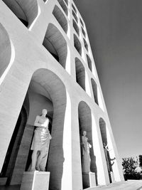 Low angle view of statues on building against sky