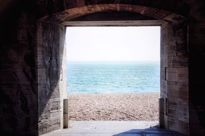 Scenic view of sea against clear sky seen through window