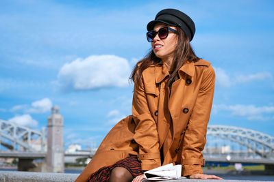 Young woman on the embankment with a newspaper in hand