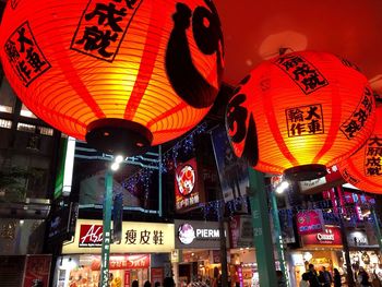 Low angle view of illuminated lanterns hanging at night