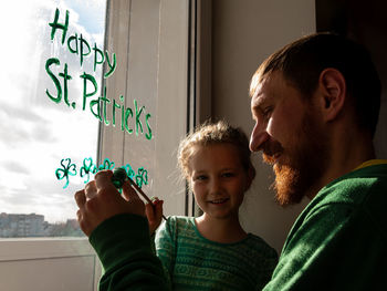 Drawing st. patrick's day father daughter painting green three-leaved shamrocks.stay home new normal