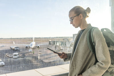 Side view of young woman using mobile phone