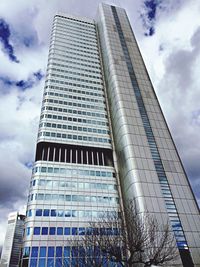 Low angle view of modern building against cloudy sky