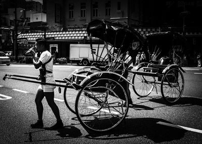 Man with bicycle standing on street in city