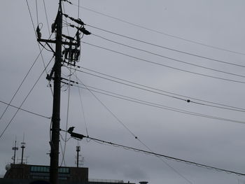 Low angle view of electricity pylon against sky