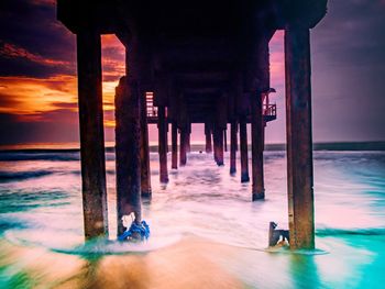 Pier on sea against sky during sunset