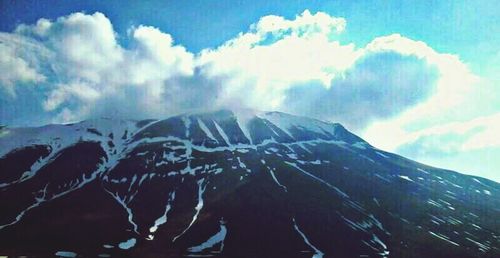 Scenic view of mountains against cloudy sky