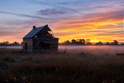 House on field against sky during sunset