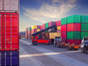 Reach stacker is working at container depot service, reach stacker lift on container to truck.