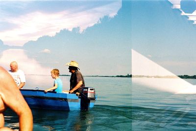 Men standing on boat in sea against sky