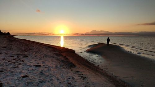 Scenic view of beach against sky during sunset