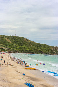 Group of people on beach against sky