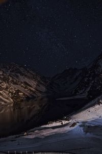 Scenic view of snowcapped mountains against sky at night