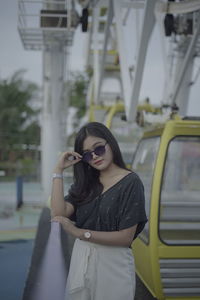 Young woman wearing sunglasses standing at bus
