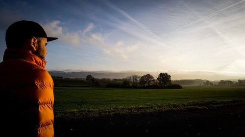 Man standing on agricultural field against sky