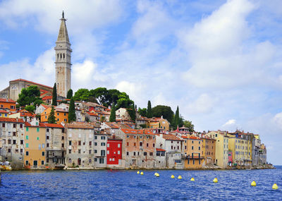 Buildings in city against cloudy sky