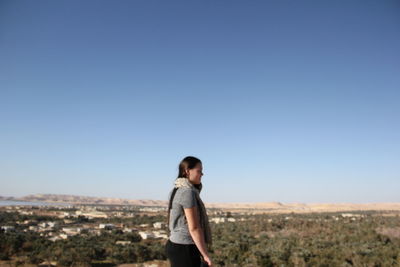 Side view of woman standing against clear sky