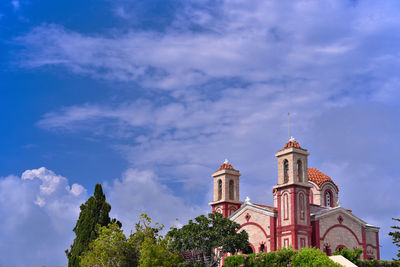 Low angle view of trees and building against sky