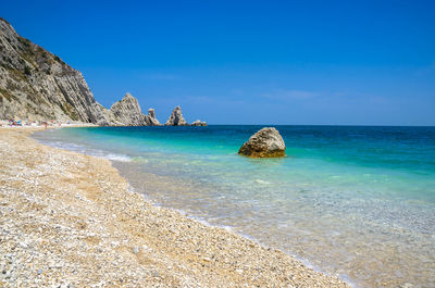 Scenic view of beach against blue sky