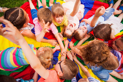 High angle view of kids stacking hands outdoors