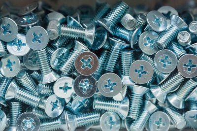 Bolt caps for a phillips screwdriver. a lot of metal screws in a glass box